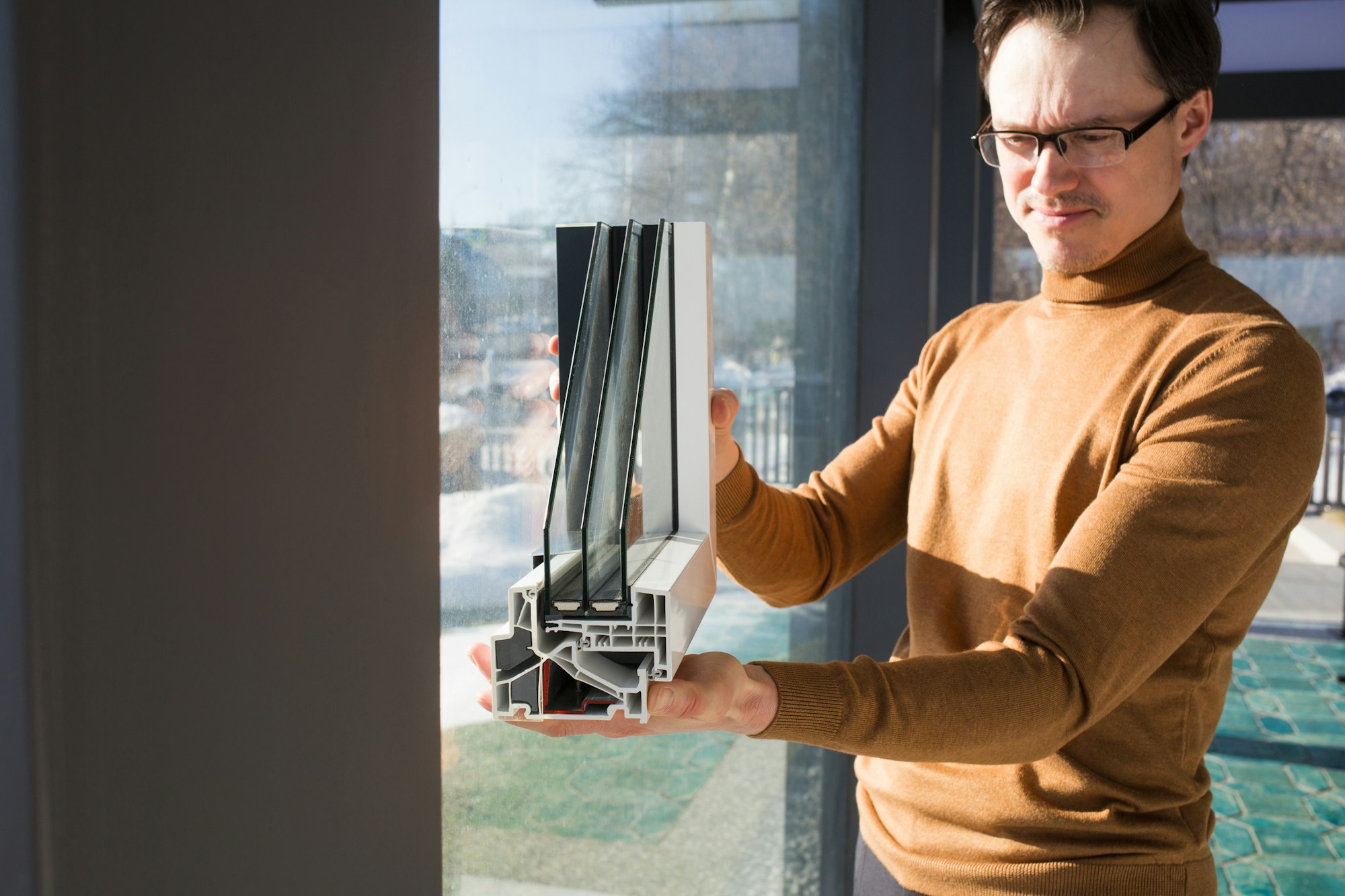 male architect engineer shows sample of double-glazed window for glazing modern glass houses