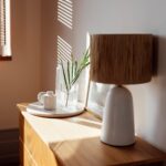 A wooden chest of drawers in the bedroom and an open window with louvered shutters.